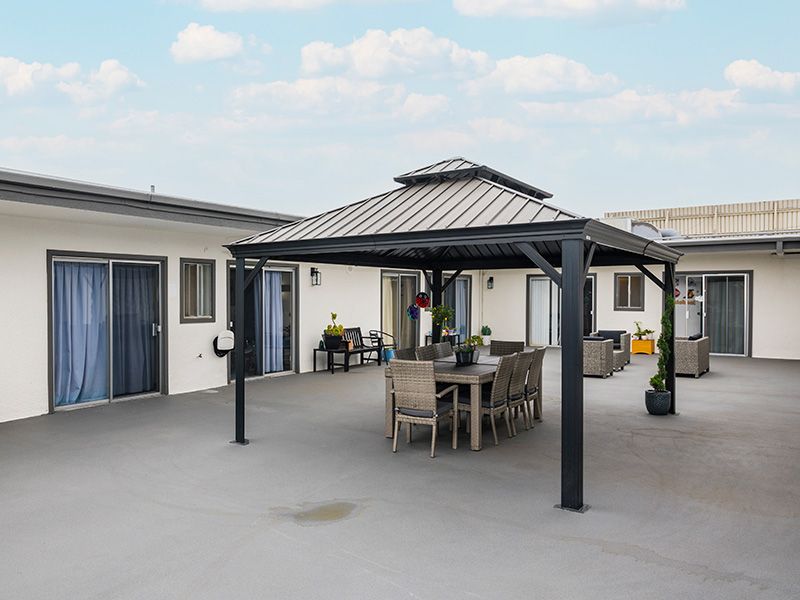 A spacious patio with a gazebo and outdoor dining set.