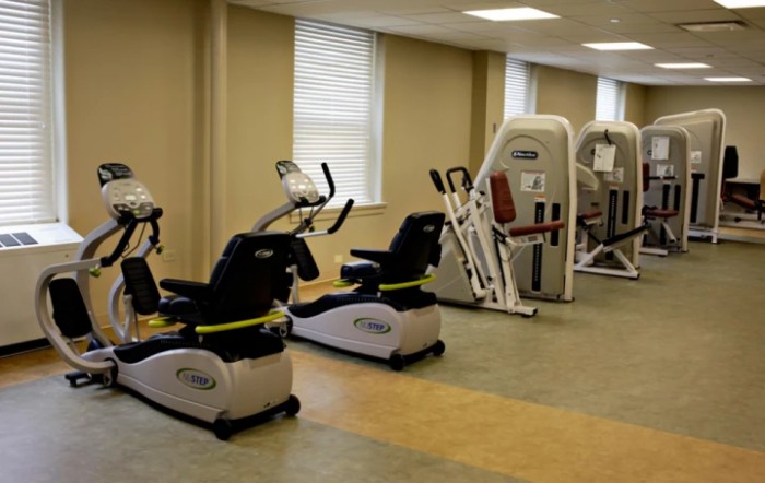 A gym with various exercise equipment including stationary bikes and strength machines.