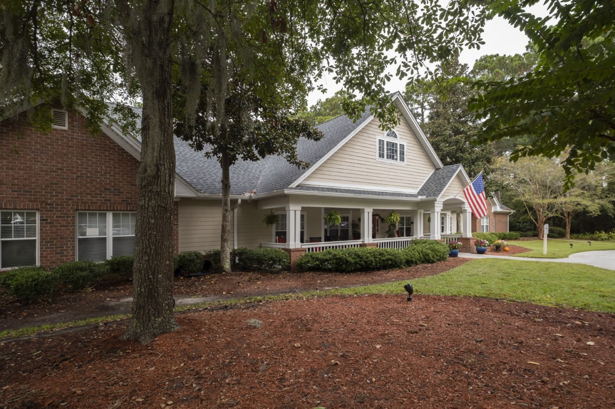 A suburban house with a well-maintained front yard and an American flag displayed.
