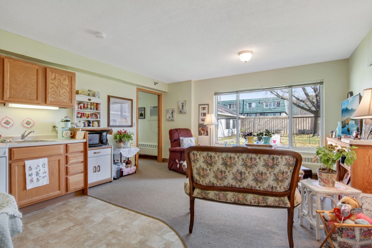 A cozy living room with vintage furniture and a large window overlooking the garden.