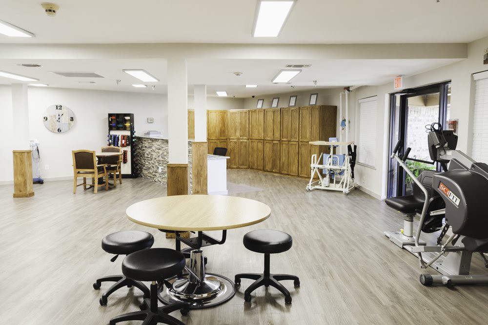 A modern interior room with tables, chairs, and storage cabinets.