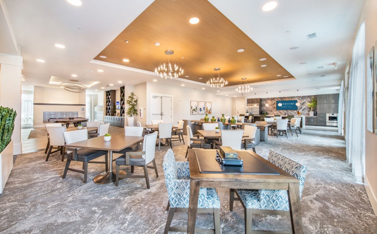 A modern dining area with elegant chandeliers and well-arranged tables and chairs.