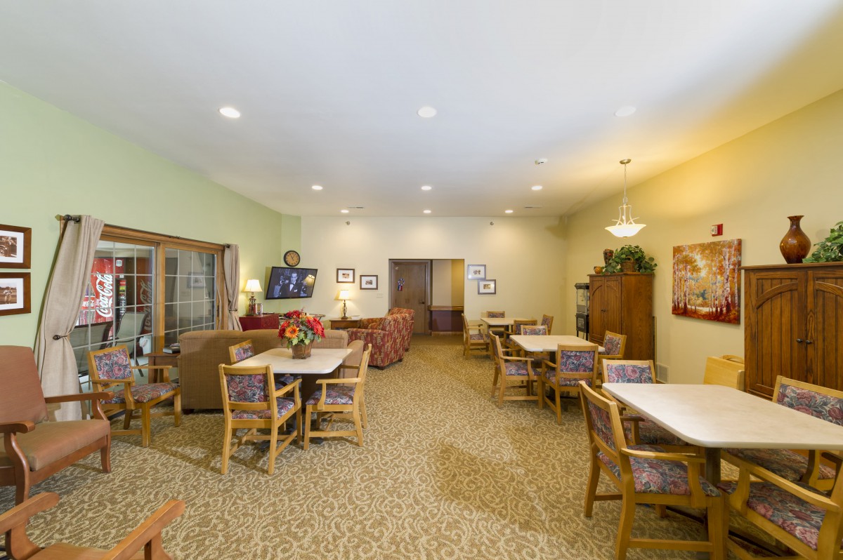 A cozy community dining area with multiple tables and chairs arranged for communal use.