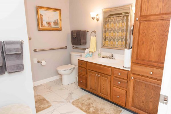 A well-appointed bathroom with a wooden vanity, large mirror, and neutral decor.
