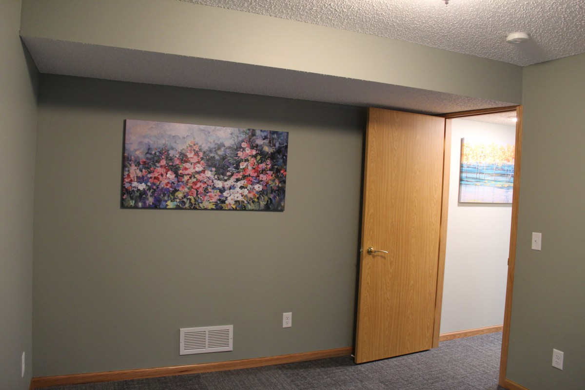 Interior room with paintings on the wall and an open door.