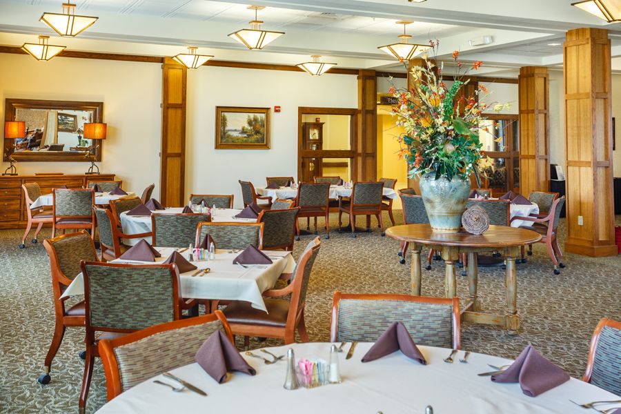 A well-arranged dining area with elegantly set tables and comfortable seating.