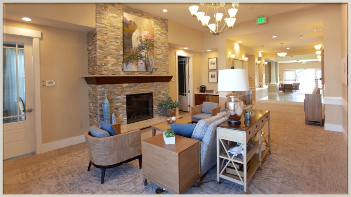 A stylish living room with modern decor featuring a stone fireplace, elegant furniture, and warm lighting.