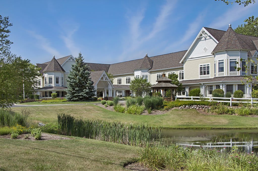 A picturesque residential complex with a pond and lush greenery.