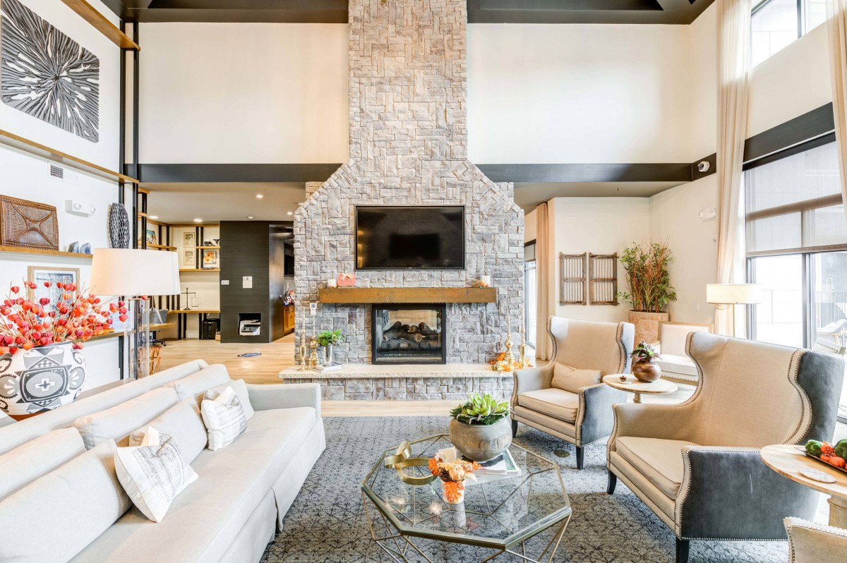 A modern living room featuring a stone fireplace and elegant furniture.