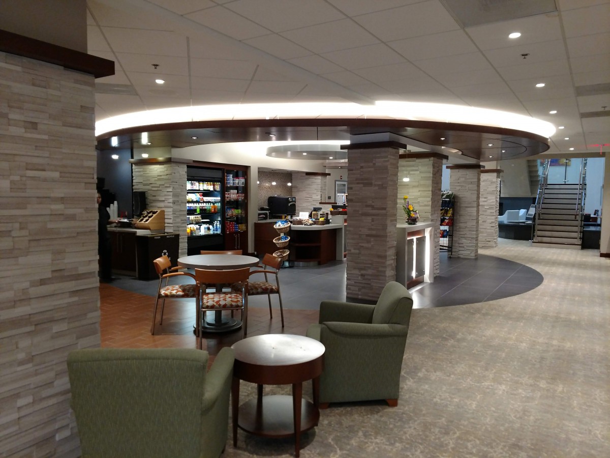 A cozy indoor lounge with seating and a coffee shop.