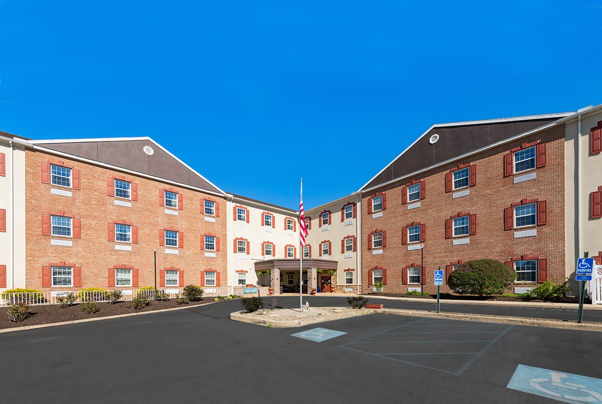 A brick hotel building with a central entrance and clear blue sky.