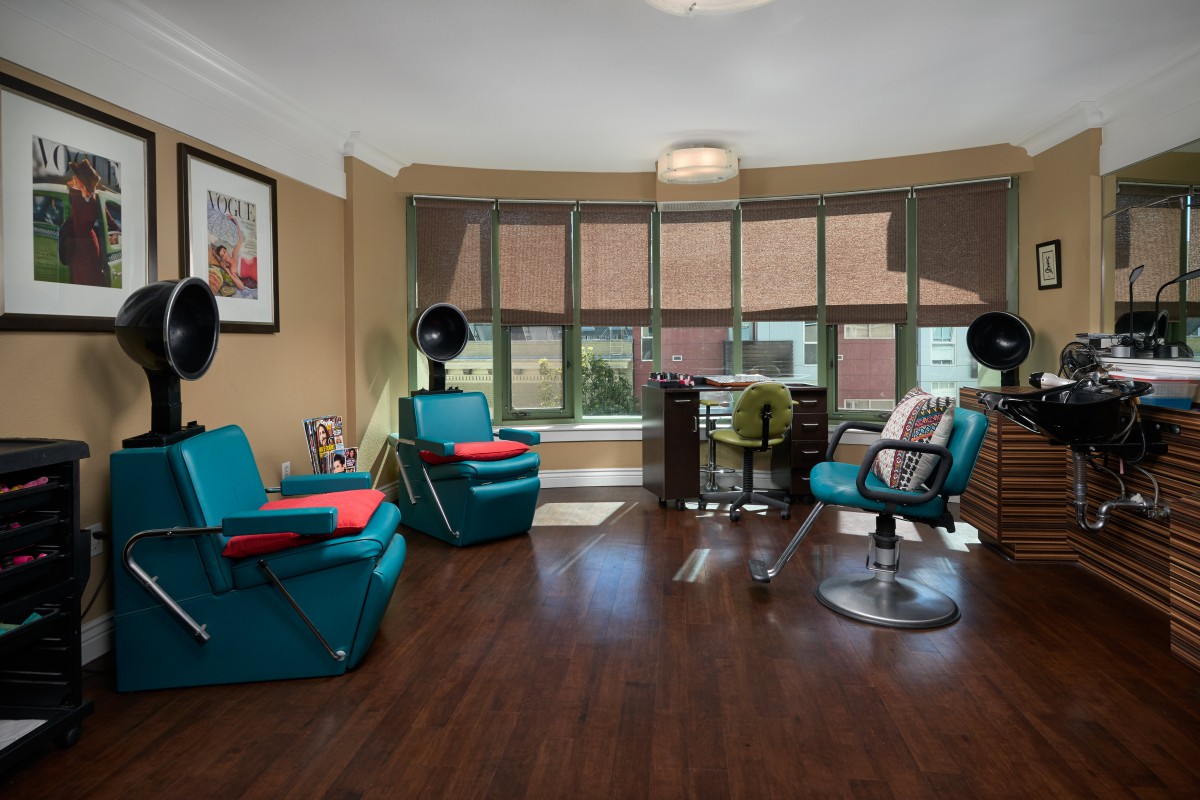 A modern hair salon with stylish chairs and large windows.