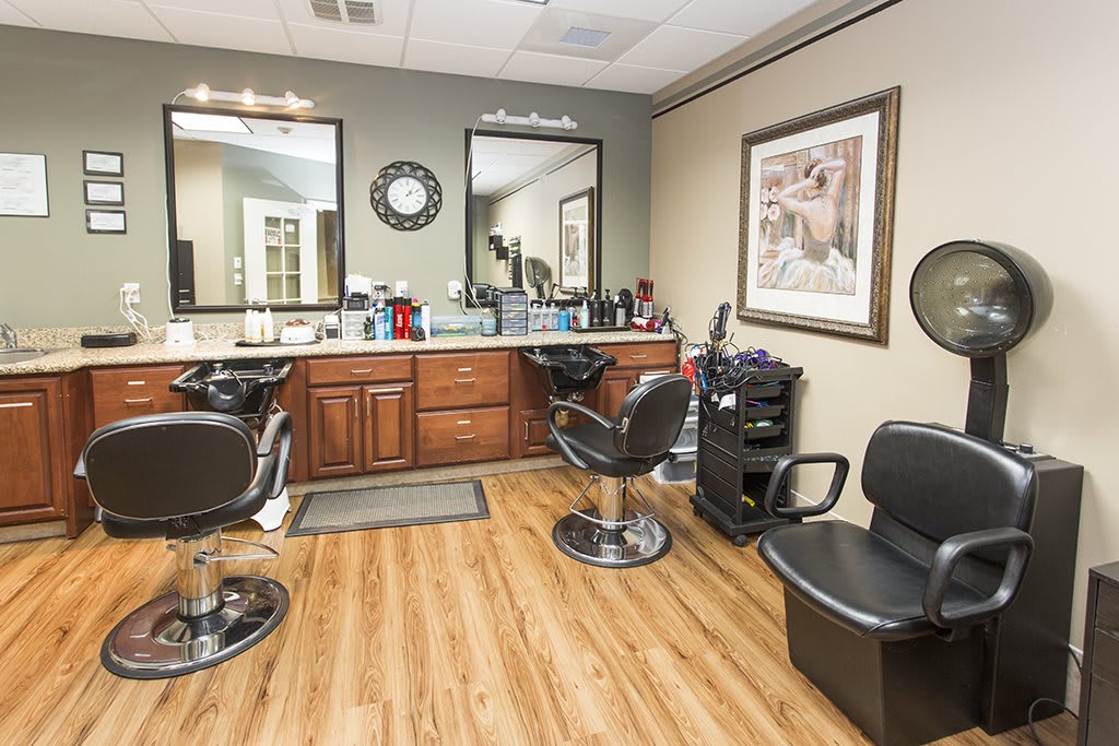 A cozy barbershop interior with styling chairs, mirrors, and hair products on display.