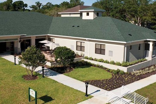 A view of a modern building with landscaped gardens and outdoor seating.