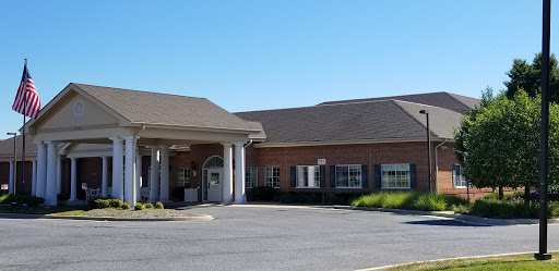 A view of a commercial building with a welcoming entrance under a clear blue sky.