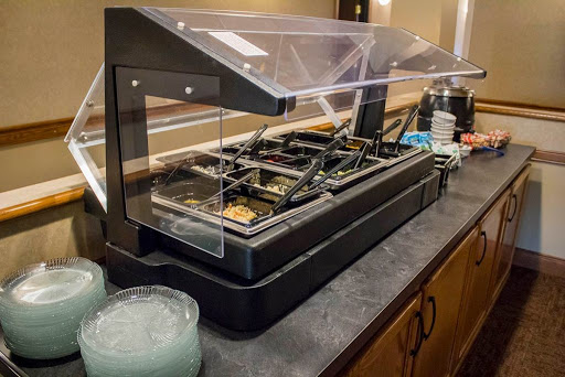 A modern food display setup featuring a variety of meal options under a transparent cover.