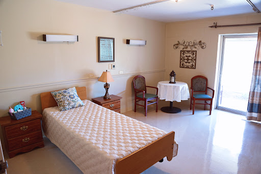 A cozy and well-furnished bedroom with a single bed, a small table, and chairs.