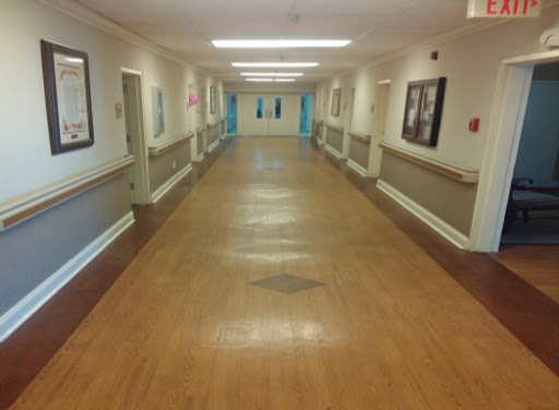 A long corridor with doors on either side, illuminated by overhead lights.