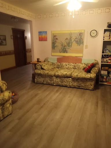 A cozy living room featuring floral-patterned furniture and decorative wall art.