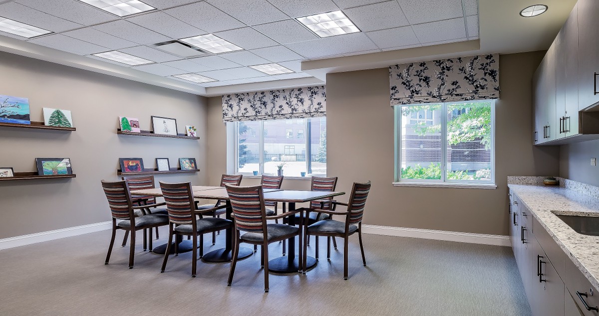 A well-lit conference room with a large table and chairs, featuring modern decor and ample natural light.