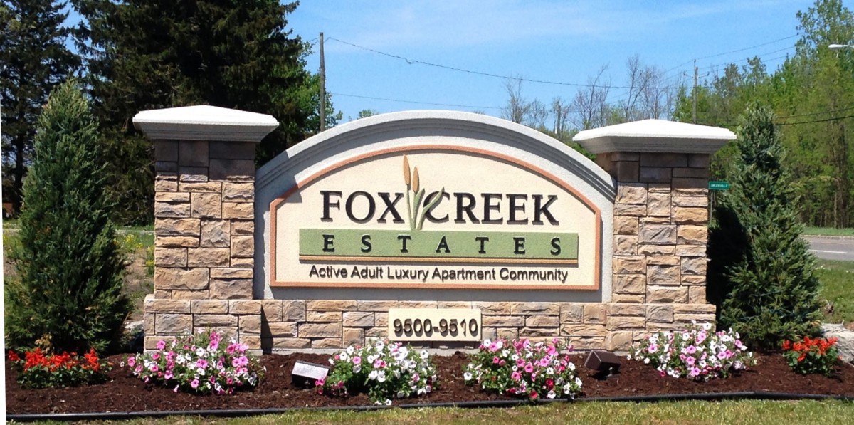 Entrance sign for Fox Creek Estates, an active adult luxury apartment community.