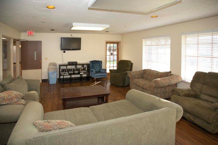 A cozy living room featuring multiple sofas, a coffee table, and a television.