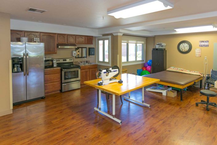 A multi-functional space with a kitchen and therapy equipment.