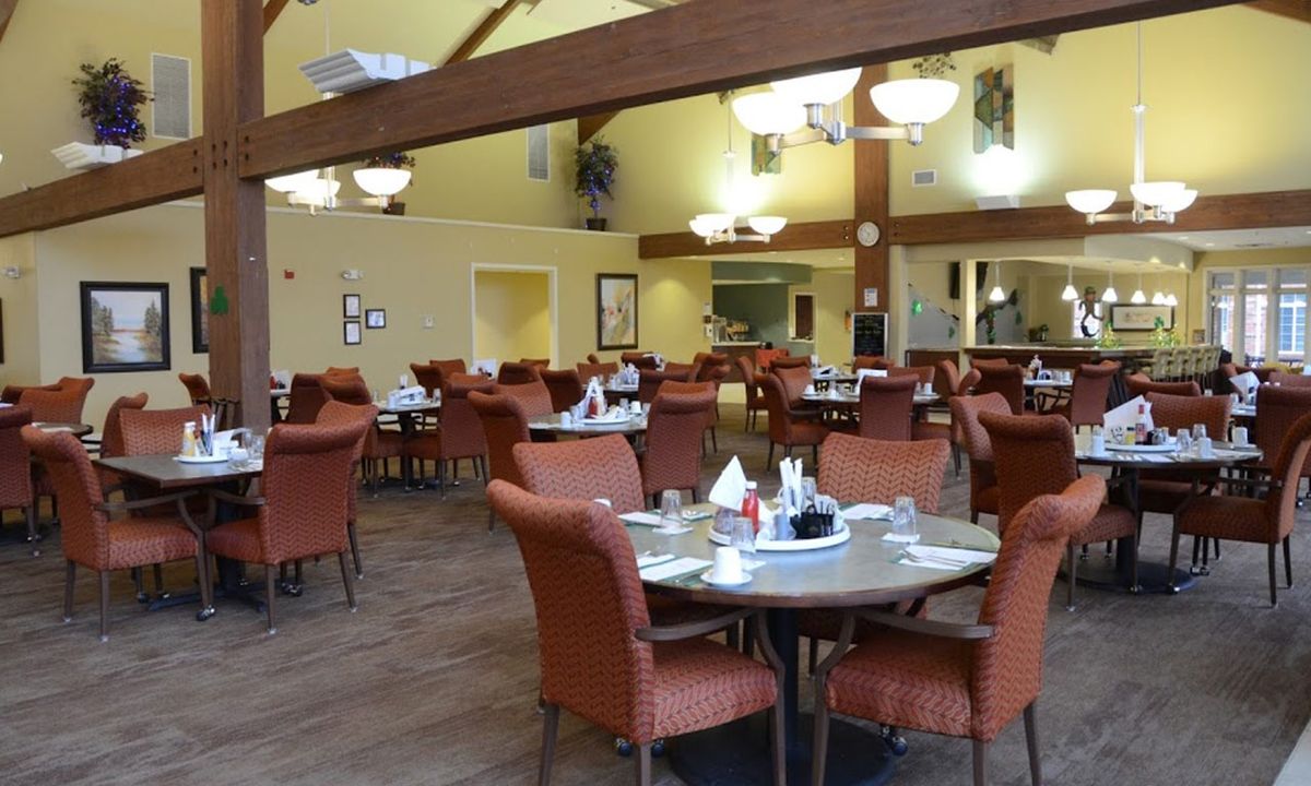 An empty dining room with neatly arranged tables and chairs.