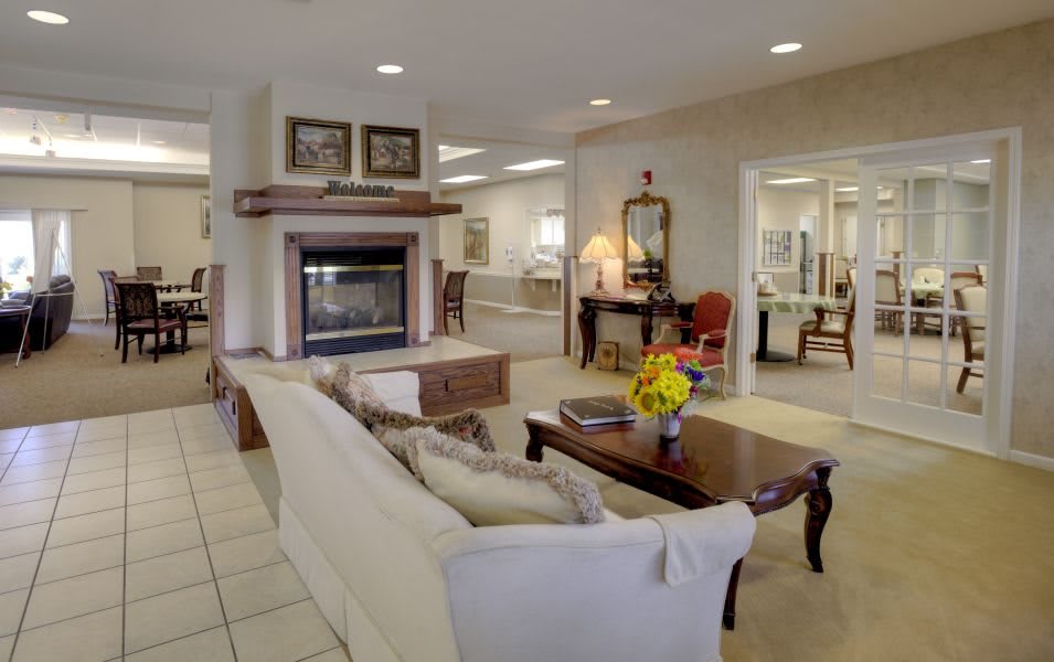A cozy and elegantly decorated living room featuring a fireplace, sofa, and coffee table.
