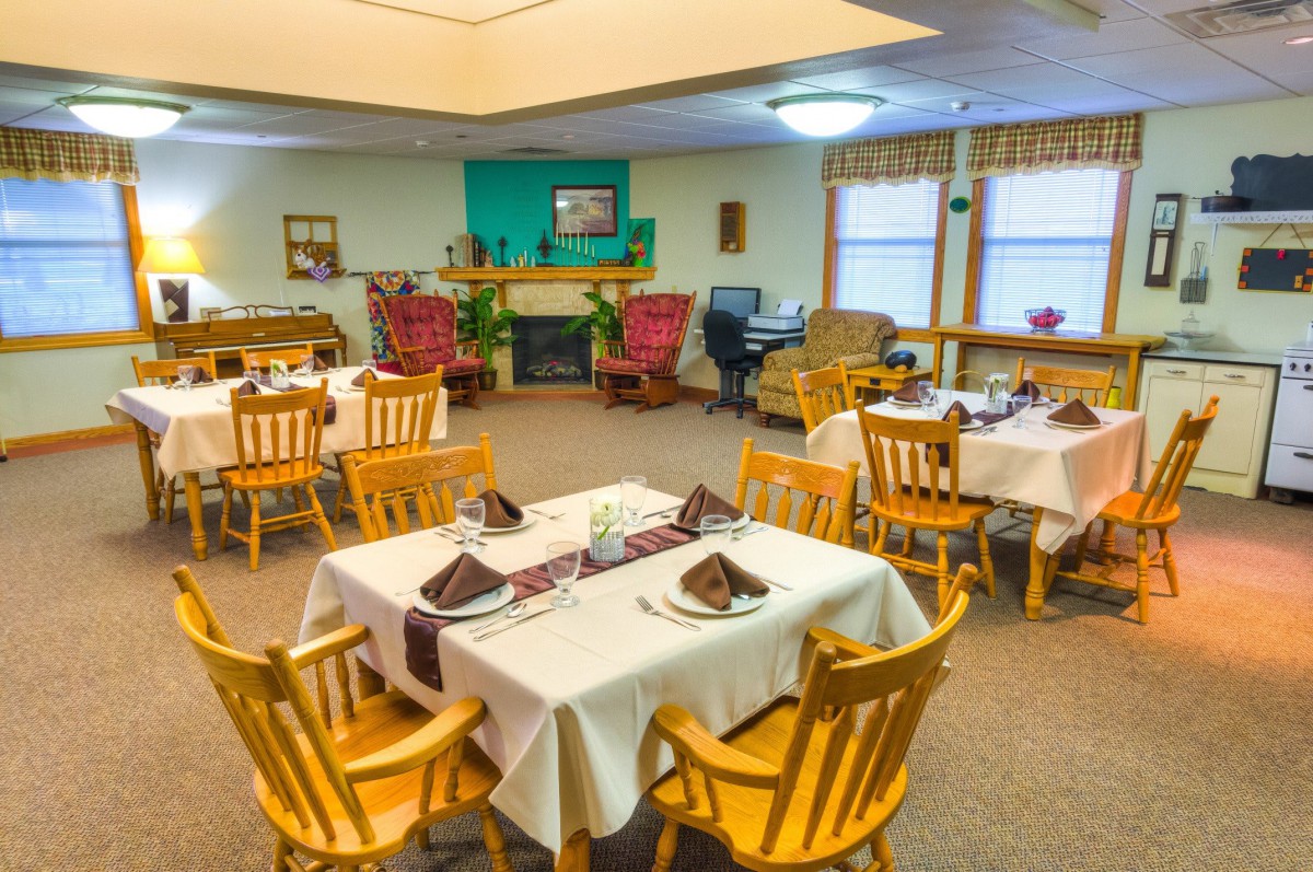A cozy dining area with neatly arranged tables and chairs, set for a meal.
