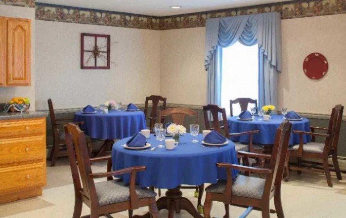 An elegantly decorated dining room with blue tablecloths and floral centerpieces.