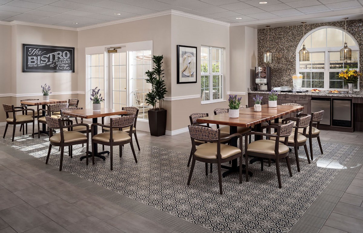 A modern dining room with wooden tables and chairs, featuring natural lighting and contemporary decor.