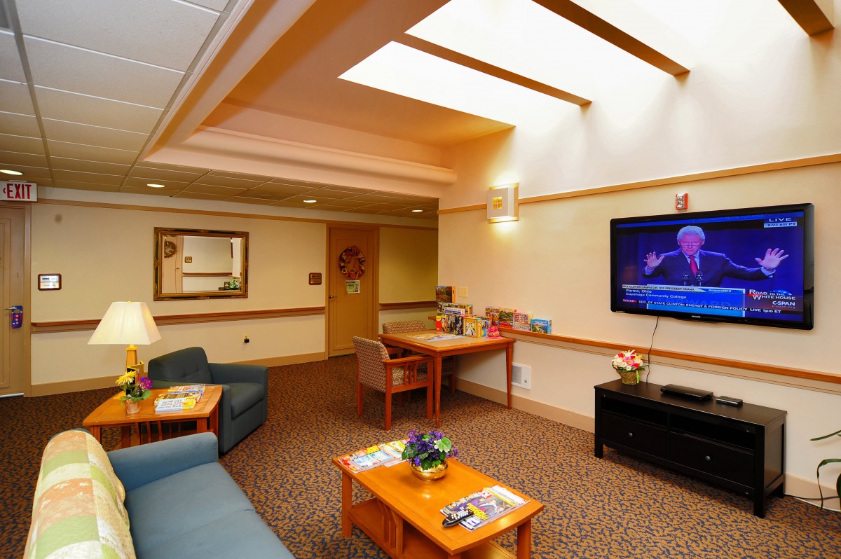 A cozy living room with comfortable seating, a television, and warm lighting.