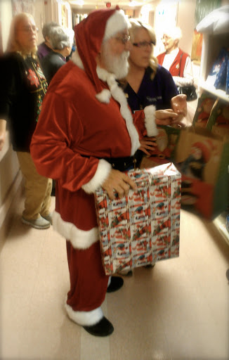 A festive Santa Claus holding a beautifully wrapped present.