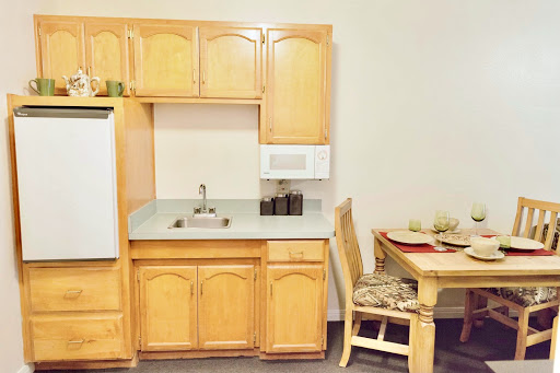 A cozy kitchen setting featuring wooden cabinetry and a small dining area.