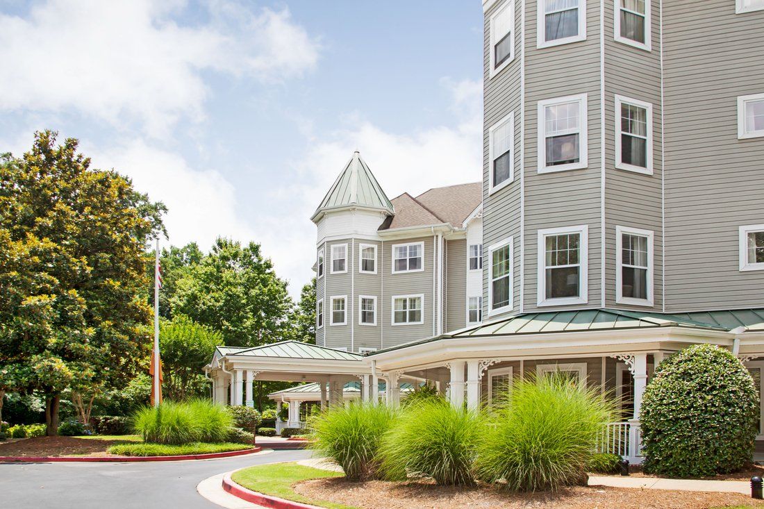 A beautiful multi-story residential building with a tower and well-maintained landscaping.