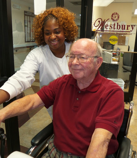 A caregiver and an elderly man sharing a joyful moment indoors.