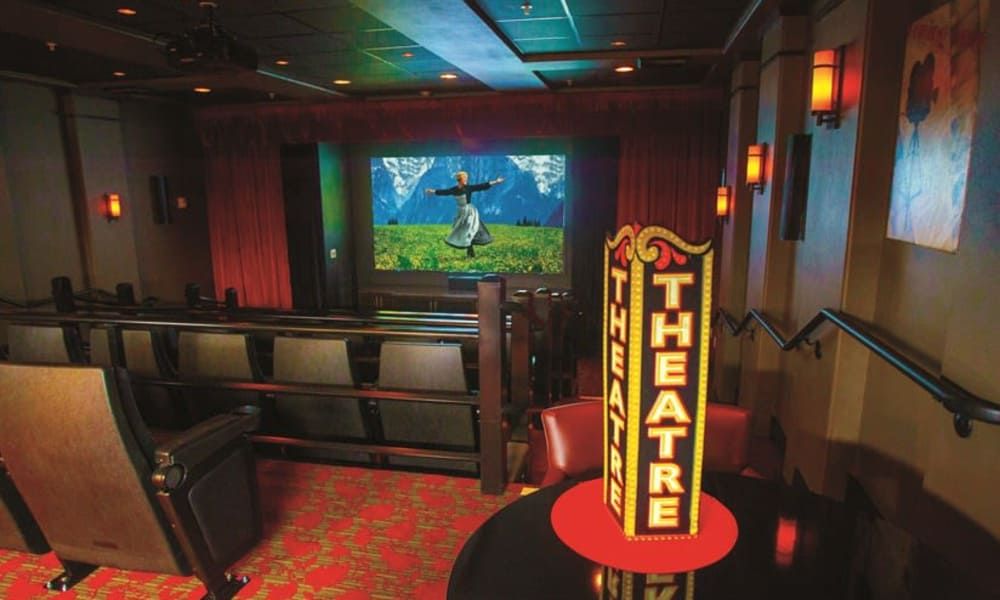 A cozy indoor theater with a screen displaying an animated film.