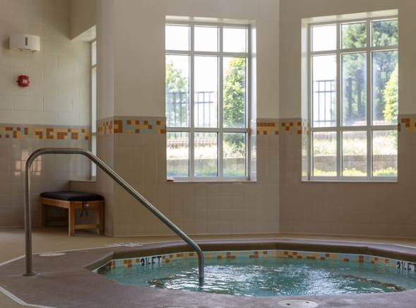 Indoor jacuzzi with large windows and natural light.