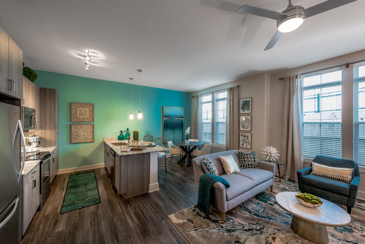 A modern open-concept apartment with a stylish living room and kitchen area.