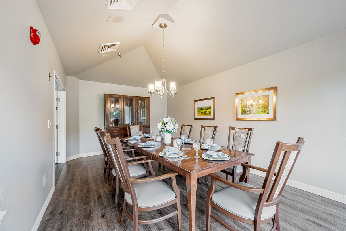A spacious and elegantly decorated dining room with a large wooden table set for a meal.