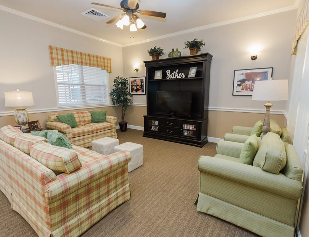 A cozy living room with patterned sofas, armchairs, and a large entertainment center.