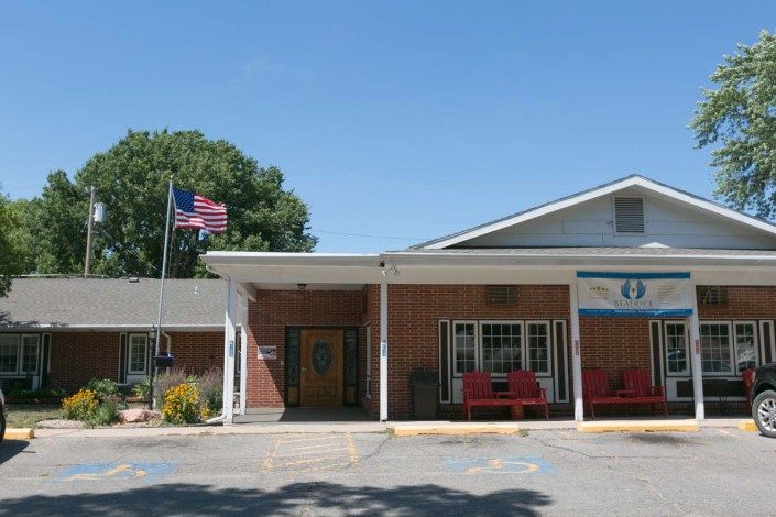 The exterior of a motel with an entrance and an American flag.