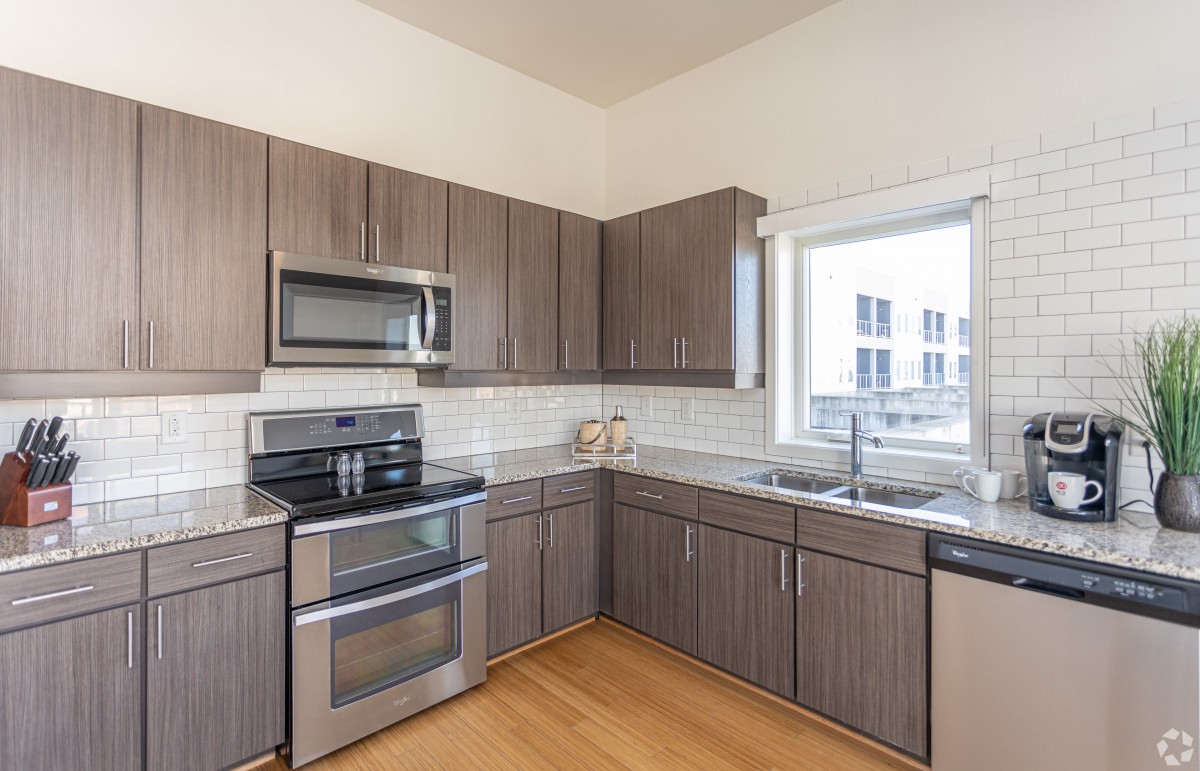 A modern kitchen with stainless steel appliances and wooden cabinets.