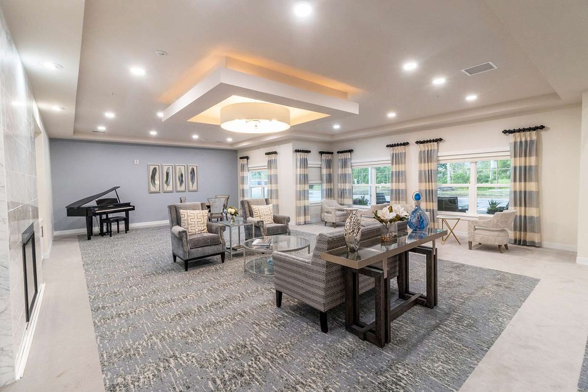 A spacious and elegantly designed living room with modern furniture and a piano.