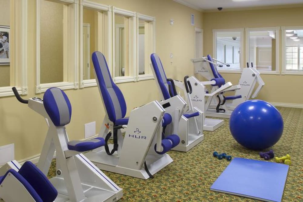 A gym room equipped with various fitness machines and exercise equipment.