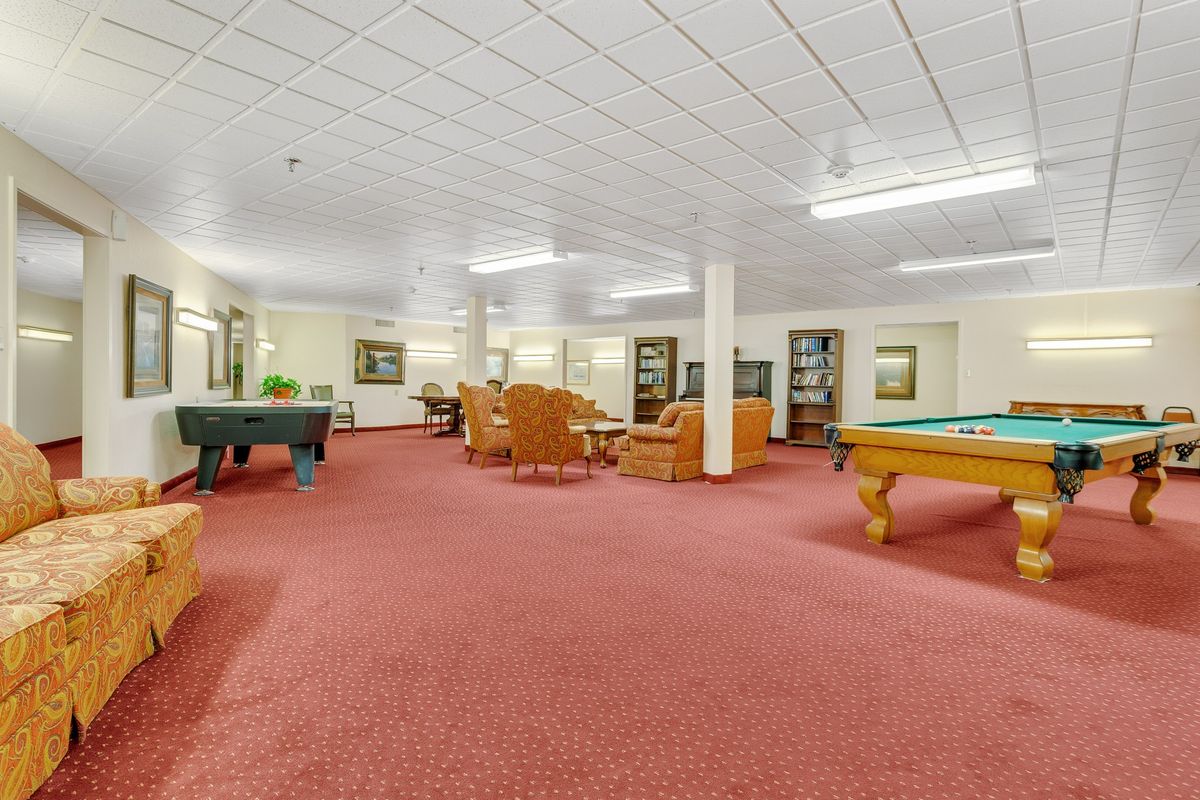 A spacious recreation room featuring pool tables and comfortable seating areas.