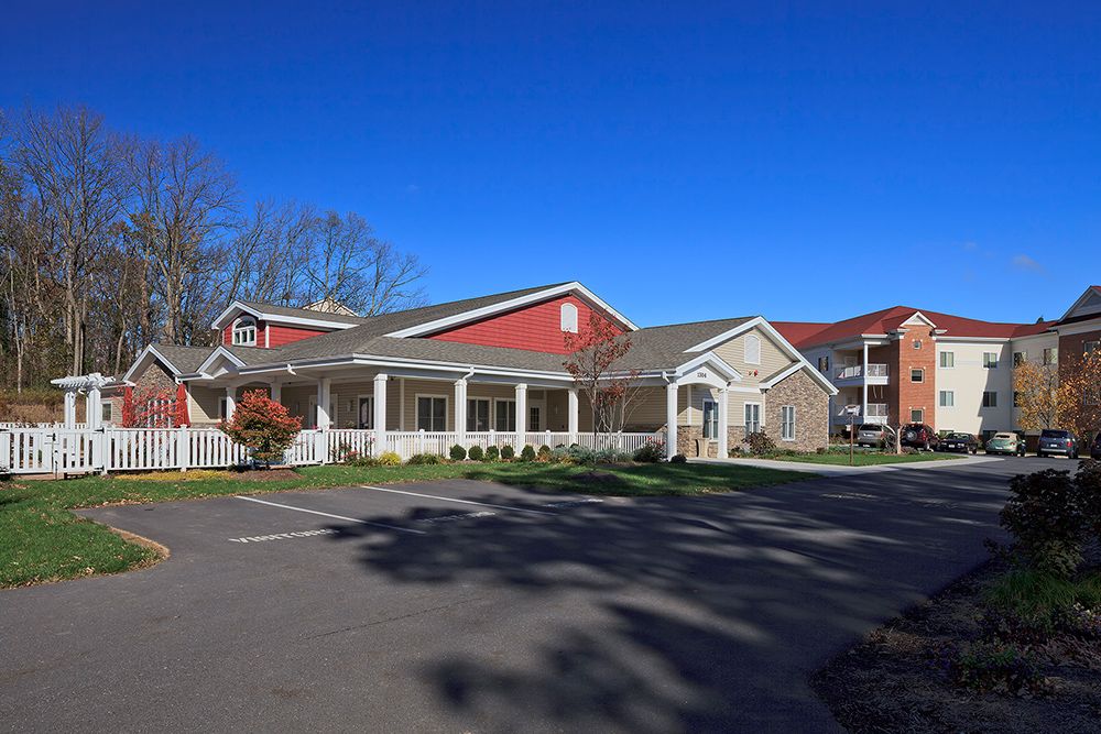 A suburban residential building with a parking lot on a sunny day.