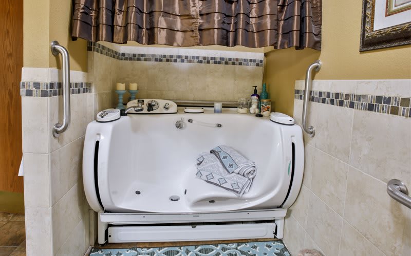 A bathroom with a jacuzzi tub, featuring towels and a decorative curtain.