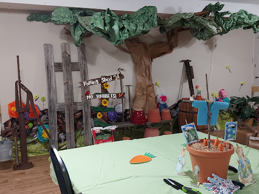 A vibrant garden-themed decoration setup with a large tree and colorful flowers, perfect for a party or craft event.
